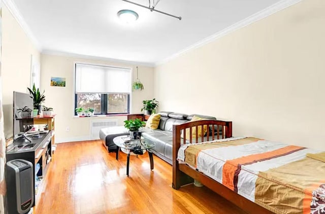 bedroom featuring light wood-type flooring, crown molding, and radiator