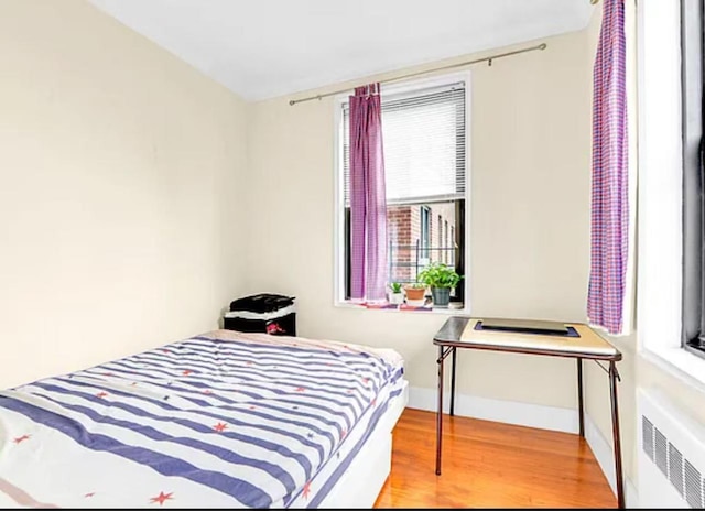 bedroom featuring hardwood / wood-style floors and radiator