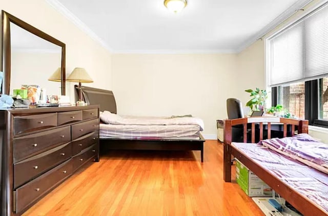 bedroom with light hardwood / wood-style flooring and crown molding