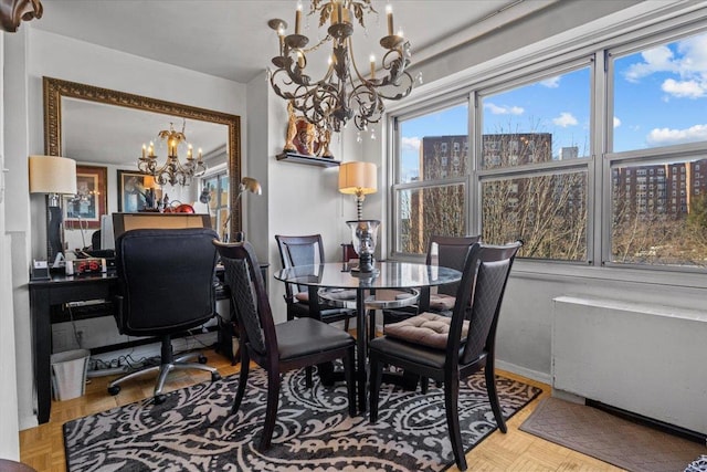 dining room featuring an inviting chandelier and parquet floors