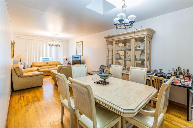 dining room featuring a notable chandelier and light wood-type flooring