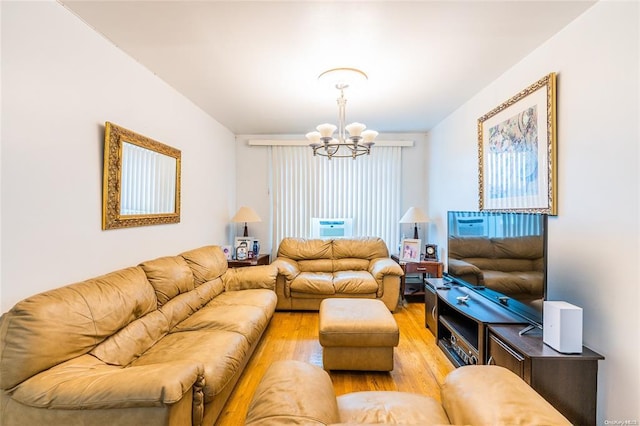 living room featuring light hardwood / wood-style flooring and an inviting chandelier