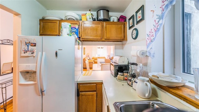 kitchen with white refrigerator with ice dispenser and sink