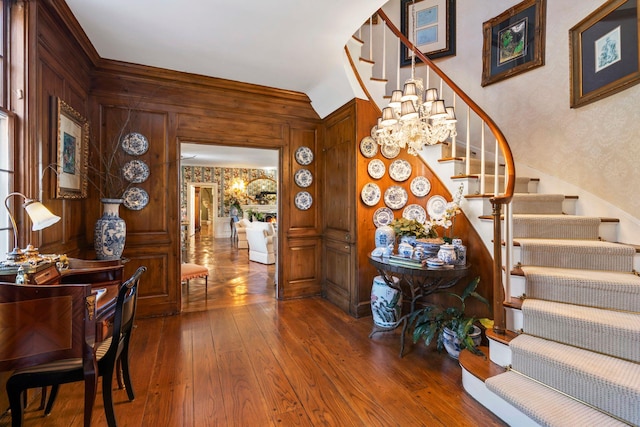 8 Stonegate Ln, Old Brookville, NY 11545 - stairway with a chandelier, wood-type flooring, and wood walls