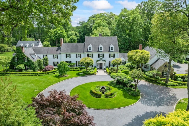 8 Stonegate Ln, Old Brookville, NY 11545 - view of front of property featuring curved driveway, a front yard, and a chimney