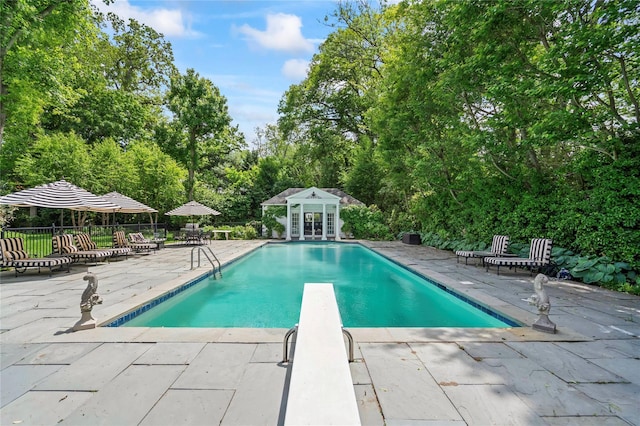 8 Stonegate Ln, Old Brookville, NY 11545 - swimming pool with a storage structure, a patio, an outbuilding, a diving board, and view of scattered trees