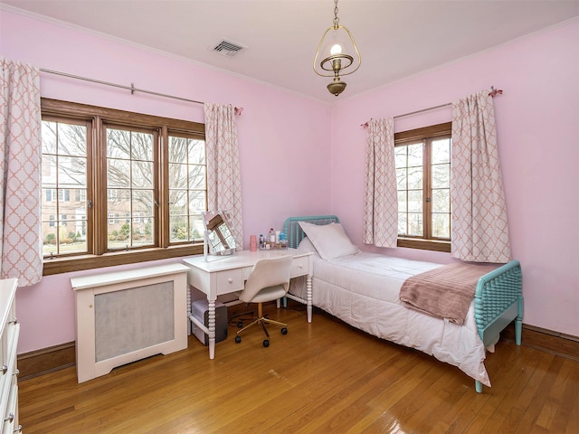 bedroom featuring radiator heating unit, baseboards, visible vents, and light wood finished floors