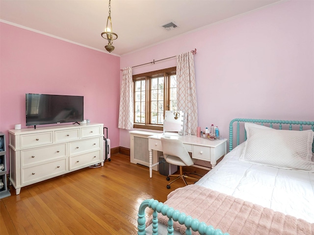 bedroom with light wood finished floors, visible vents, and crown molding