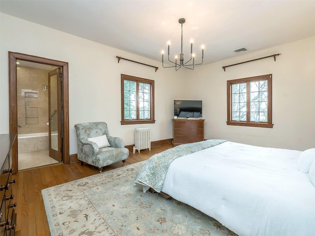 bedroom with radiator heating unit, multiple windows, a chandelier, and wood finished floors