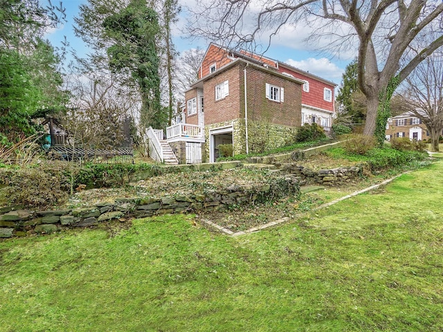 view of yard with a garage and stairway