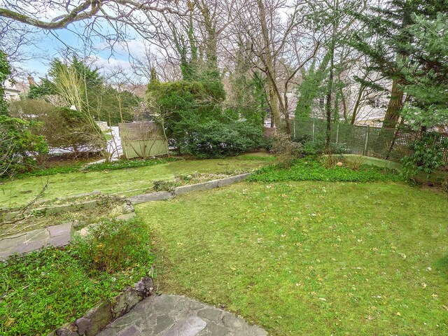 view of yard featuring a shed, fence, and an outdoor structure