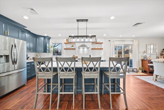 kitchen with open shelves, tasteful backsplash, stainless steel refrigerator with ice dispenser, and visible vents