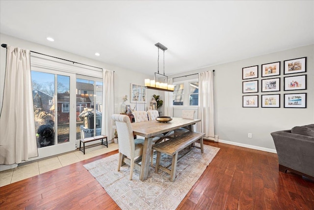 dining space with recessed lighting, wood finished floors, an inviting chandelier, and baseboards