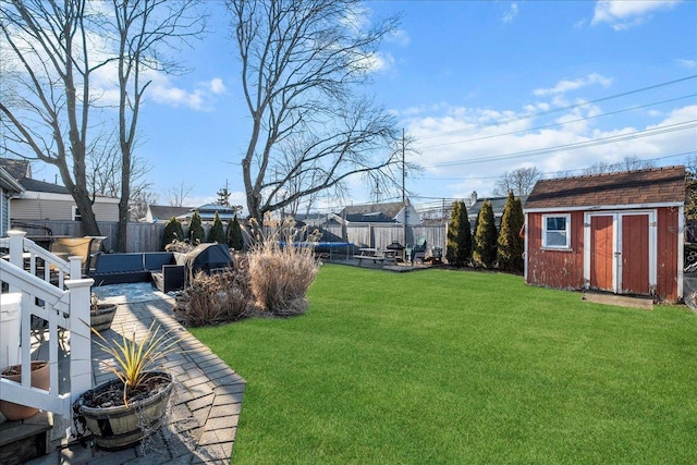 view of yard featuring a shed, a fenced backyard, and an outdoor structure