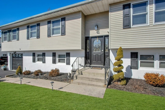 view of front facade with a garage, stucco siding, driveway, and a front yard