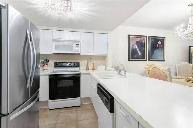 kitchen with white cabinetry, decorative light fixtures, sink, white appliances, and a chandelier