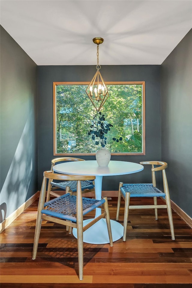 dining space with a chandelier, baseboards, and wood finished floors