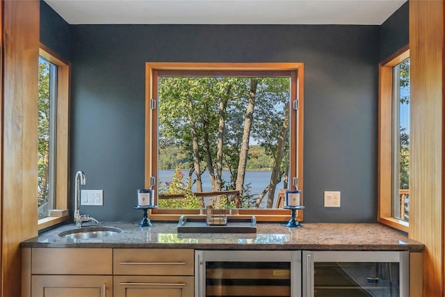 bar featuring wine cooler, bar, a water view, and a sink