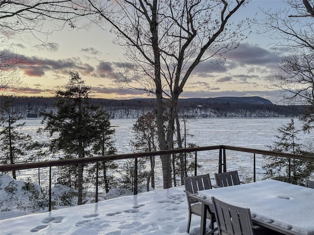 snow covered deck with a mountain view