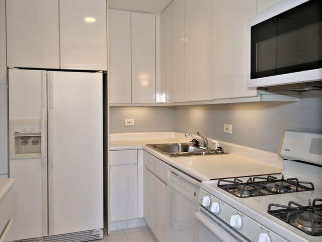 kitchen featuring light countertops, white appliances, white cabinets, and modern cabinets