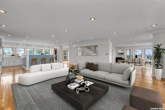 living area featuring light wood-style floors, stairway, and recessed lighting