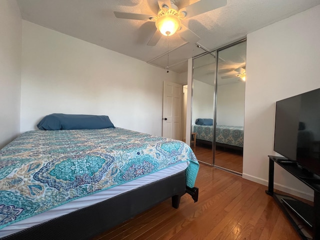 bedroom featuring a closet, ceiling fan, hardwood / wood-style flooring, and baseboards