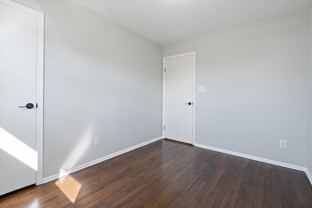 unfurnished room featuring dark wood finished floors and baseboards