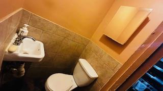 bathroom featuring tile walls and toilet