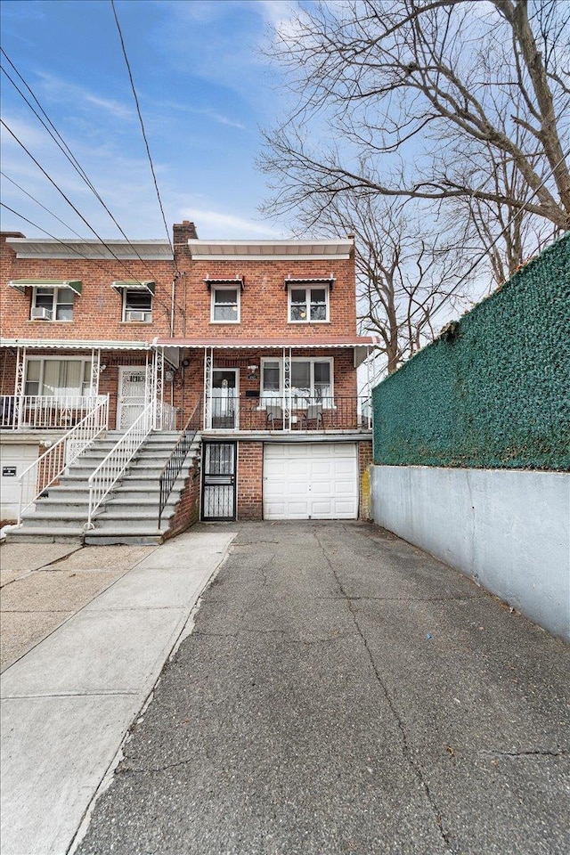 view of front facade featuring brick siding, driveway, an attached garage, and fence