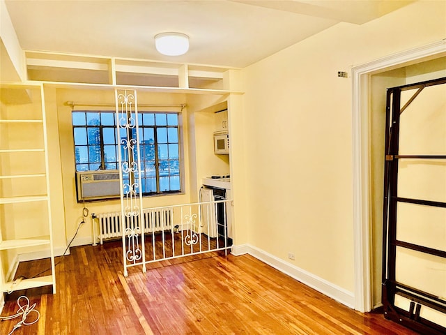 dining room featuring radiator, hardwood / wood-style flooring, and cooling unit