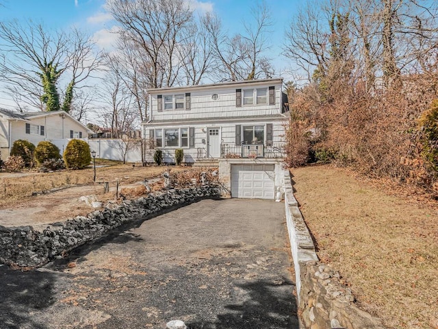 shingle-style home featuring a garage and aphalt driveway