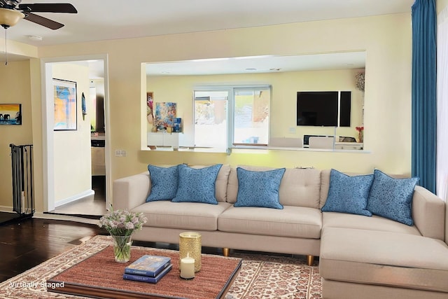 living area featuring ceiling fan, baseboards, and wood finished floors