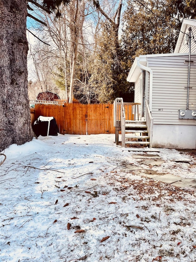 yard covered in snow featuring fence