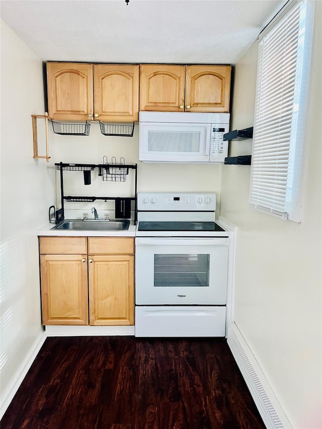 kitchen featuring white appliances, light brown cabinets, light countertops, and a sink