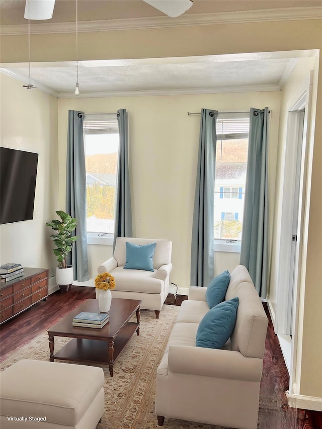 living room featuring baseboards, ornamental molding, and wood finished floors