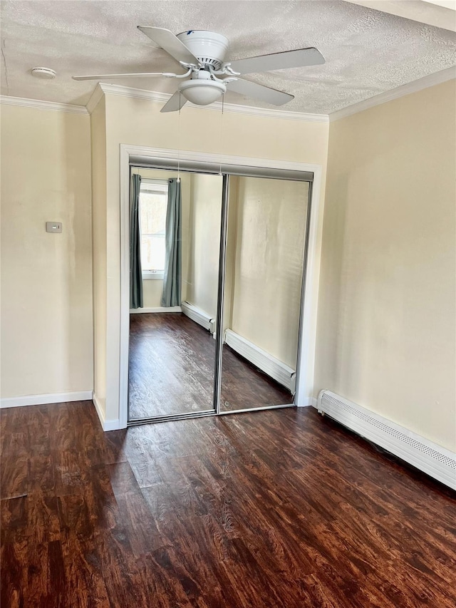 unfurnished bedroom with ornamental molding, dark wood finished floors, a textured ceiling, and baseboard heating