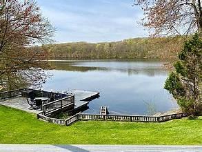 view of dock featuring a water view and a lawn