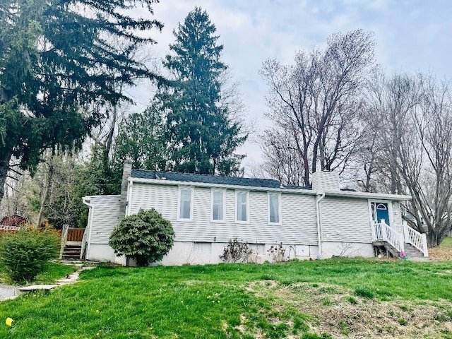 view of home's exterior with a lawn and a chimney