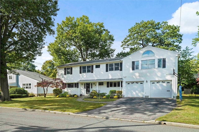view of front facade featuring a front lawn, driveway, and a garage