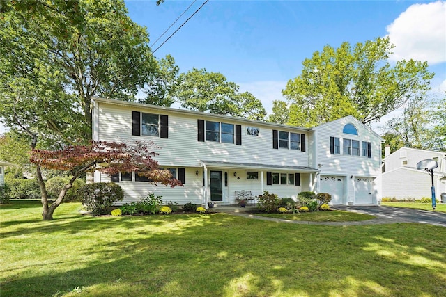 colonial inspired home with an attached garage, driveway, and a front yard