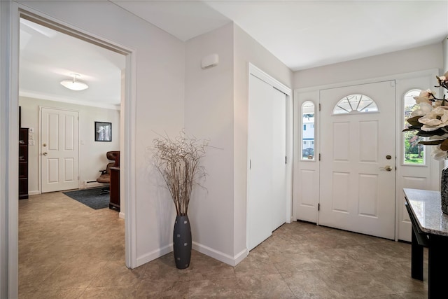 foyer with baseboards, plenty of natural light, and a baseboard heating unit