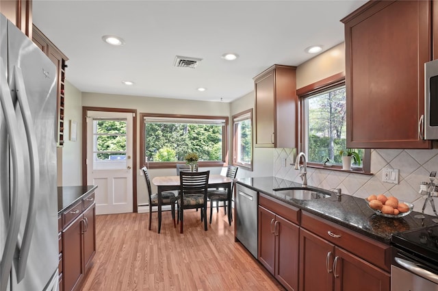 kitchen featuring a wealth of natural light, stainless steel appliances, visible vents, and a sink