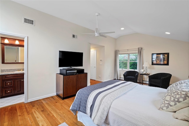 bedroom with light wood finished floors, visible vents, baseboards, and lofted ceiling