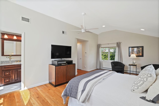 bedroom with vaulted ceiling, light wood-type flooring, visible vents, and a baseboard heating unit