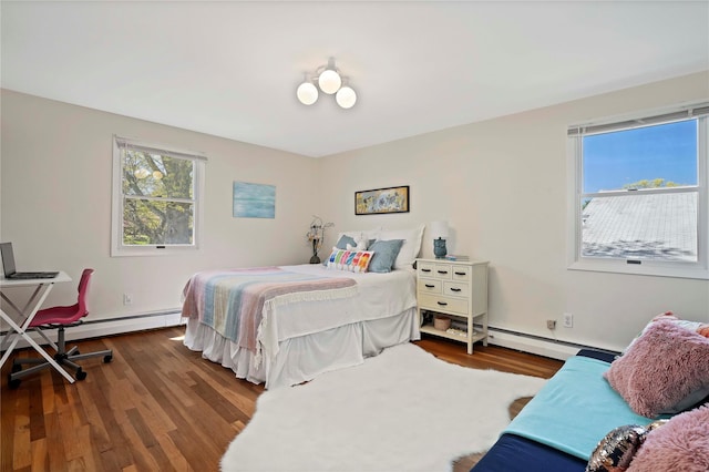 bedroom featuring baseboard heating and wood finished floors