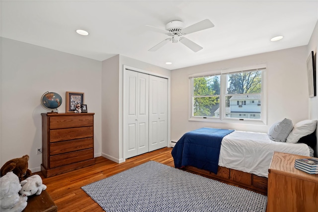 bedroom featuring recessed lighting, a closet, baseboard heating, and wood finished floors