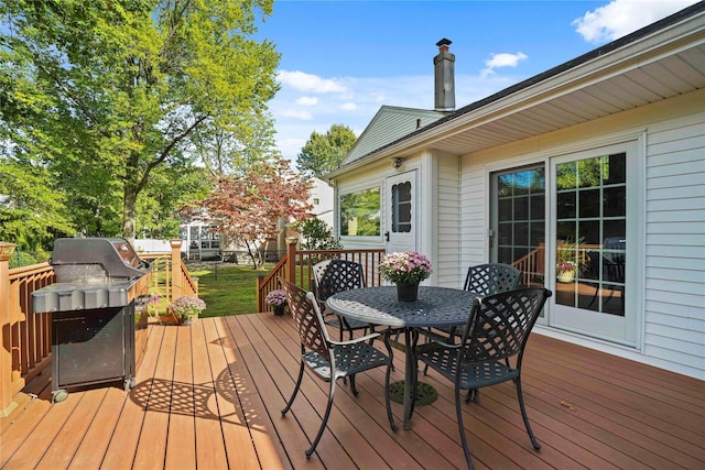 wooden deck with area for grilling and outdoor dining space