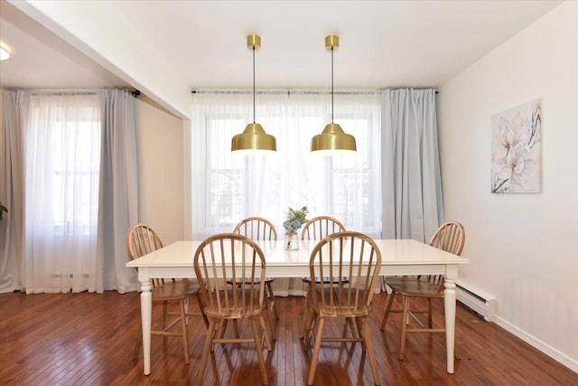 dining space featuring a baseboard radiator, baseboards, and dark wood-style flooring