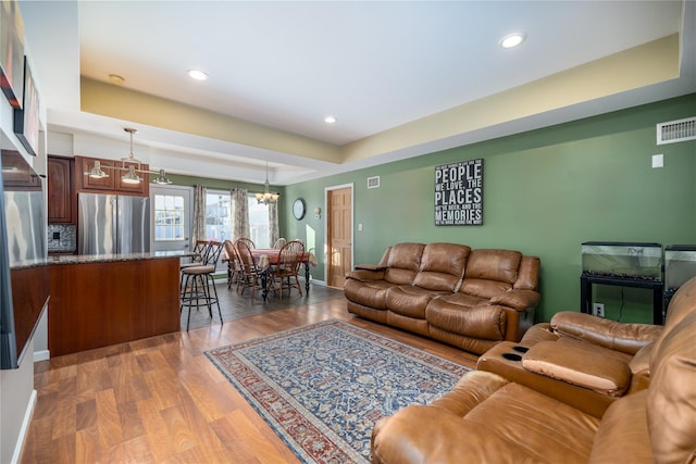 living room with recessed lighting, visible vents, light wood-style floors, a chandelier, and baseboards