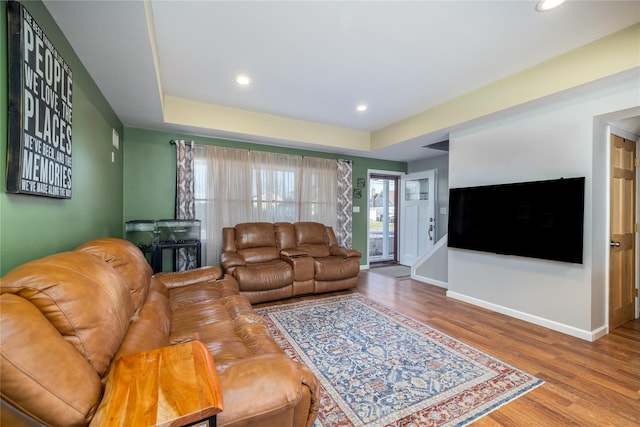 living area featuring baseboards, wood finished floors, and recessed lighting